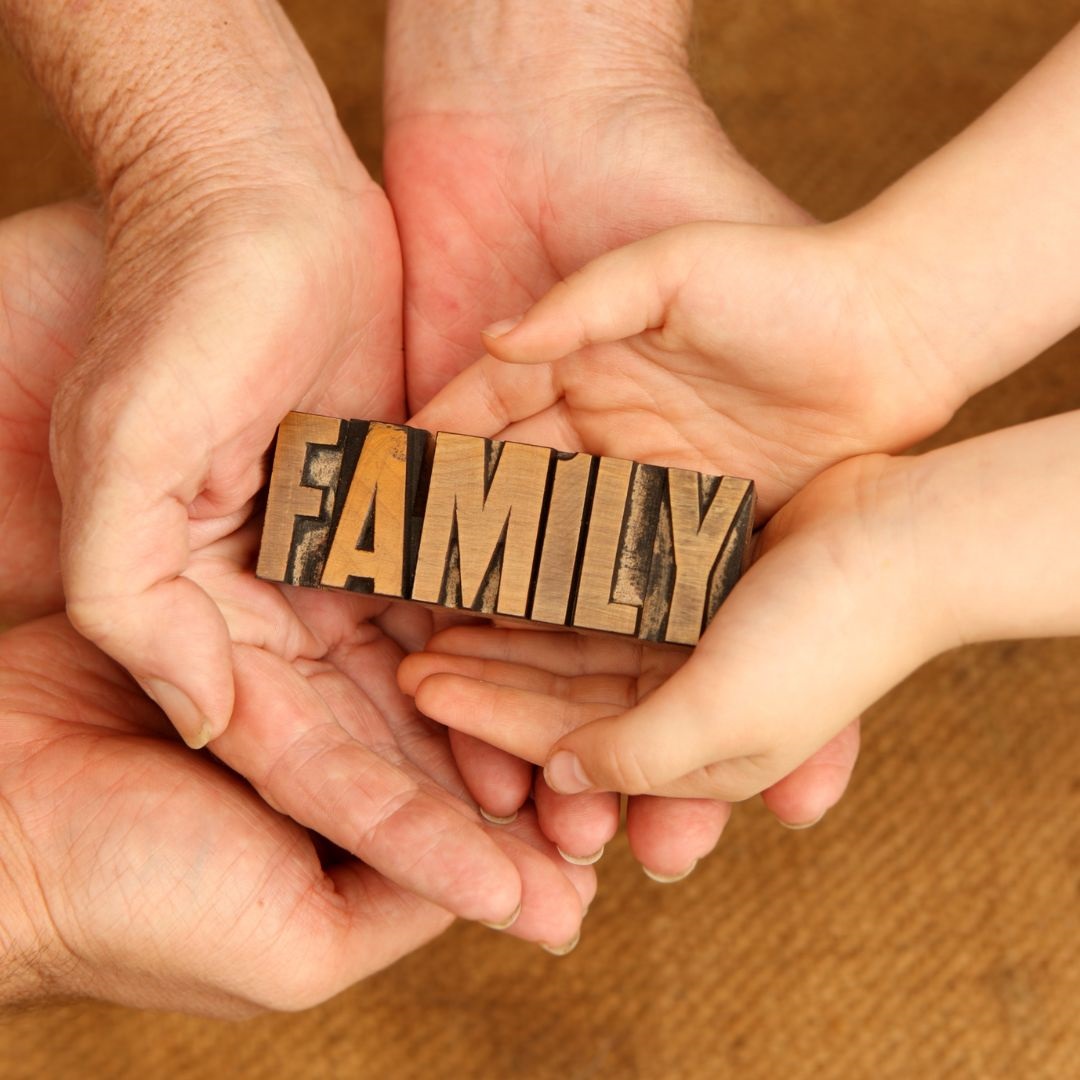 Hands holding wooden family sign